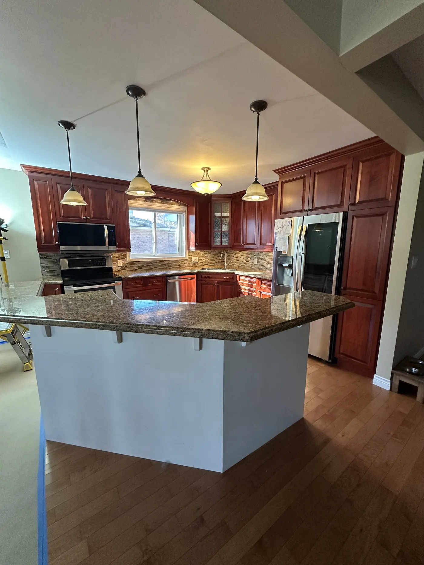 Dark cherry kitchen cabinets before refinishing in a North Bay home