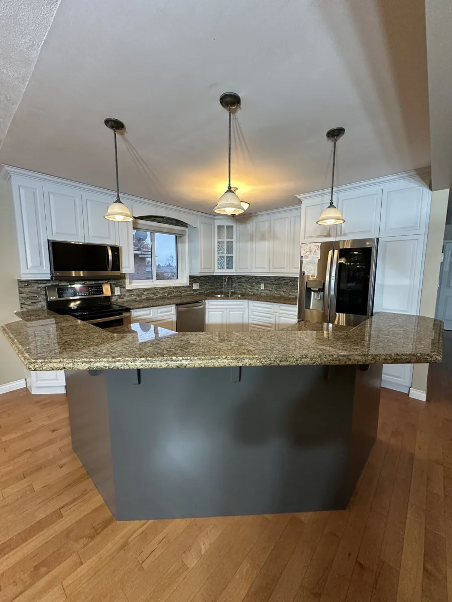 Same kitchen with bright white sprayed cabinets after refinishing